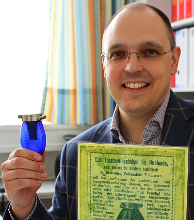 Hygienefachkraft Christian Schoßmeier mit dem historischen Fläschchen namens „Blauer Heinrich“. -  Foto: Klinik Mallersdorf