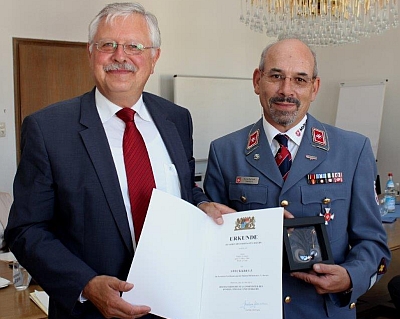 Regierungspräsident Heinz Grunwald überreichte Rainer Zollitsch das Steckkreuz des Freistaates Bayern für seine Verdienste um den Malteser-Hilfsdienst. Foto: Regierung von Niederbayern. 