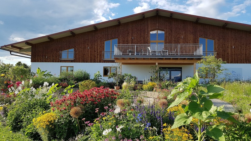 Schaugarten des EM-Chiemgau in Stephanskirchen-Högering mit bepflanzten Beeten und gestalteten Gartenflächen.