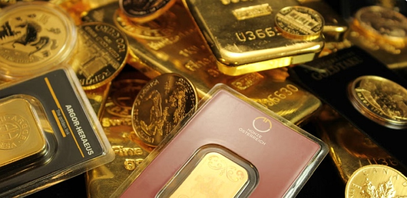 Mehrere Goldbaren und Münzen liegen dicht beieinander, teils in Kunststoffverpackungen